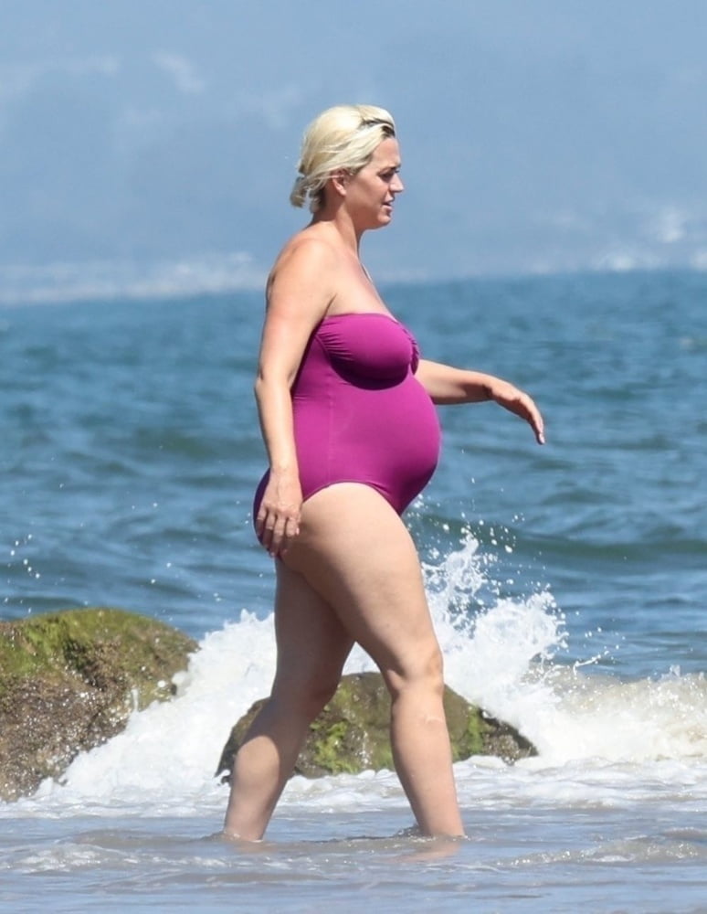 Pregnant Katy Perry in a purple swimsuit.
